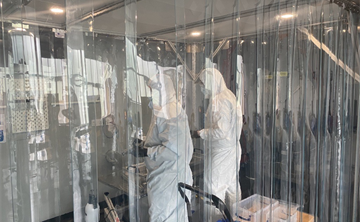 Two people in PPE standing in a cleanroom