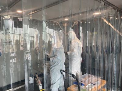 Two people in PPE standing in a cleanroom
